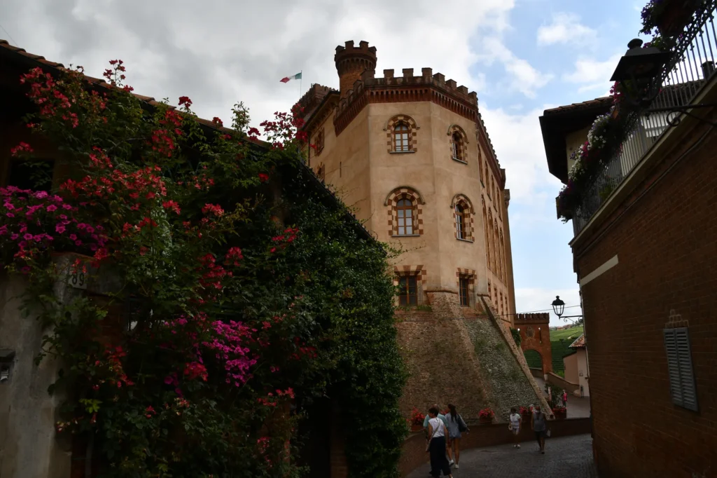 De vierkante toren van het Castello Falletti in Barolo, met bloemen langs de muur